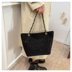 Detailed view of black leopard print suede tote bag with woven chain strap and soft texture