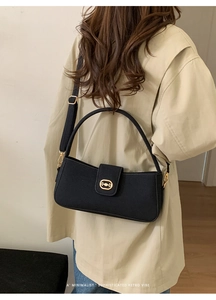 Detail of retro black shoulder bag with golden horsebit hardware and canvas strap