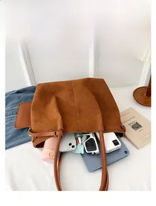 Spacious interior of brown suede tote bag showing tablet, phone, and daily essentials