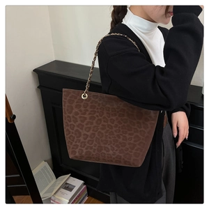 Detail of leopard print tote bag with gold chain strap and suede texture finish