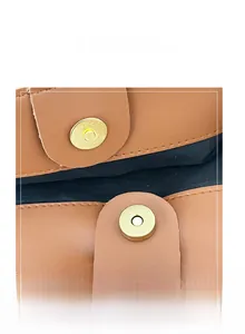 Detail shot of the golden magnetic buckle closure on a brown pebble leather tote bag