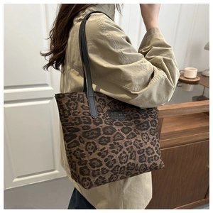 Detailaufnahme der Tragetasche mit Leopardenmuster, schwarzen Riemen und Modeetikett