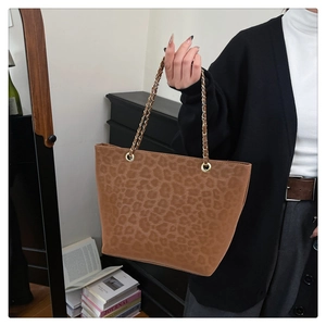 Close-up of leopard print tote bag with gold chain strap and suede texture