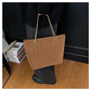 Detail of leopard print tote bag with gold chain strap and spacious interior design
