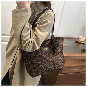 Detail of leopard print tote bag with black shoulder strap on beige trench coat outfit
