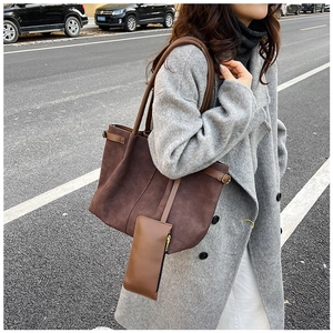 Detail of matte brown tote bag with leather straps and detachable small pouch