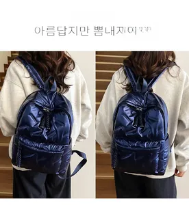 Detail of navy blue puffer backpack with glossy metallic texture and quilted pattern