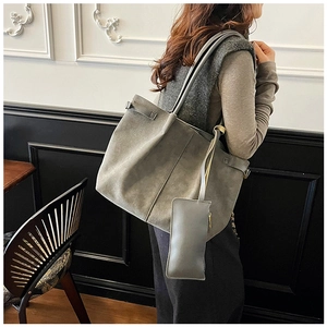 Macro shot of a dark gray faux suede tote bag with matching strap and detachable coin purse