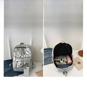 Detailed interior of a silver quilted backpack showing large capacity compartments