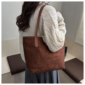 Detail of dark brown faux suede tote bag showing texture and slim shoulder straps