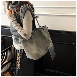 Detail of grey suede tote bag featuring interior zipper pouch and vintage gold hardware