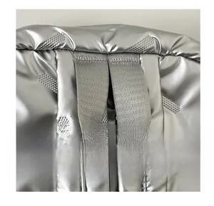 Detail of silver metallic quilted backpack showing durable top handle and texture