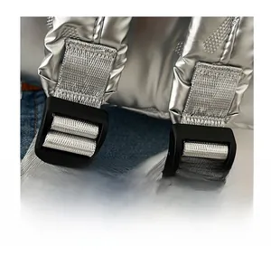 Close-up of adjustable shoulder straps and black buckles on metallic silver backpack