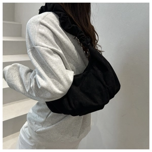 Détail du sac cabas matelassé noir montrant la texture plissée et la bandoulière souple