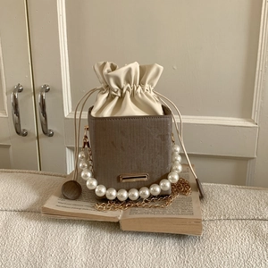 Sac seau vintage en cuir marron avec anse en perles et chaîne dorée élégante