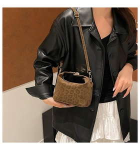 Brown leopard print crossbody bag styled with black leather jacket and white dress