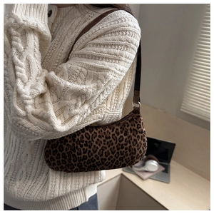 Détail du sac baguette léopard avec bandoulière en similicuir marron sur l'épaule