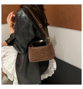 Brown leopard print suede shoulder bag with metal lock shown on model with black jacket