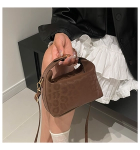 Close-up of brown leopard embossed texture and golden buckle on mini crossbody bag