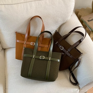 Three retro suede texture crossbody bags in green, caramel, and brown on a soft sofa