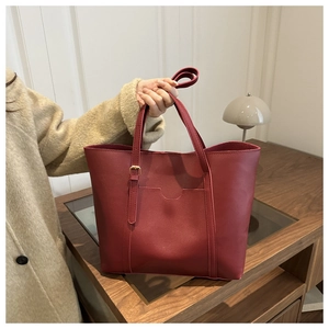 Detail of burgundy PU leather tote bag showing textured surface and adjustable buckle strap