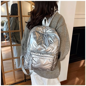 Detail of silver metallic quilted backpack with glossy finish and woven zipper pulls