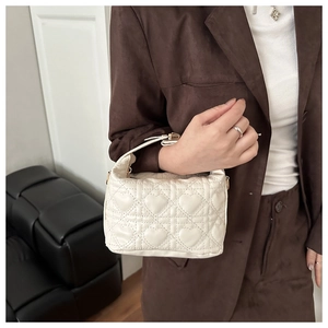 Detailed view of white mini quilted handbag with 3D heart embroidery and gold hardware