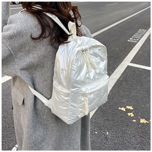 White quilted backpack with glossy finish shown from a back view on a female model