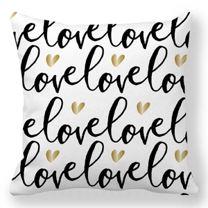 Macro detail of white peach skin pillowcase with black love script and gold hearts
