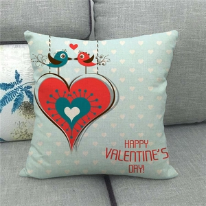 Close-up of Happy Valentine's Day linen pillow cover with cartoon birds on a gray sofa