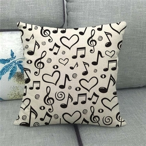 Primer plano de funda de cojín de lino con notas musicales y patrones de corazón