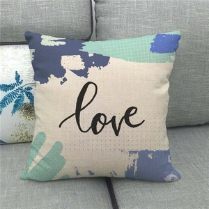 Close-up of linen cushion cover with blue abstract art and cursive love text