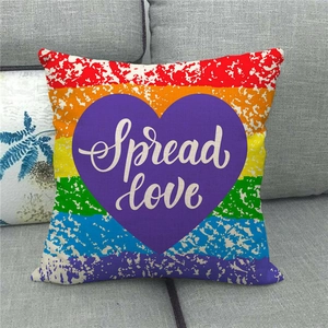Rainbow striped linen pillow cover with purple heart and Spread Love text on gray sofa