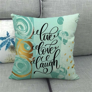 Close-up of linen pillowcase with Live Love Laugh print on mint green background