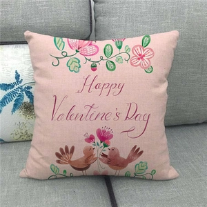 Close-up of Happy Valentine's Day linen pillowcase with birds and floral design on a sofa