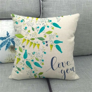 Linen cushion cover with botanical print and Love You text on a grey fabric sofa
