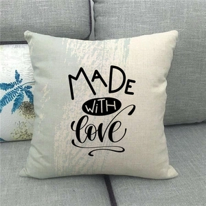 Detail of linen cushion cover featuring black MADE WITH LOVE text and blue brush stroke