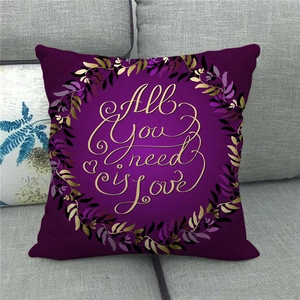 Macro shot of purple linen pillowcase with gold 'All you need is Love' wreath print