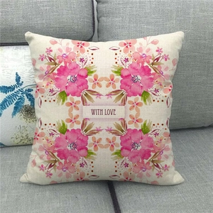 Close-up of linen pillow cover featuring floral patterns and 'WITH LOVE' text on a sofa