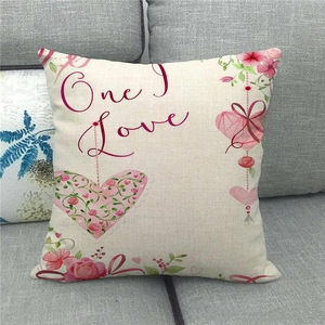 Detail of linen Valentine's pillowcase with 'One Love' print on a grey sofa fabric