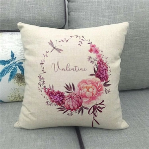 Close-up of linen pillowcase with floral Valentine heart print on grey sofa