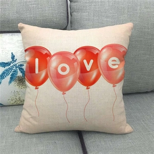Linen pillow cover featuring red love balloon print on a grey sofa background
