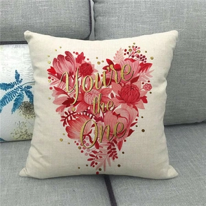 Close-up of linen pillow cover featuring floral heart design and gold text detail