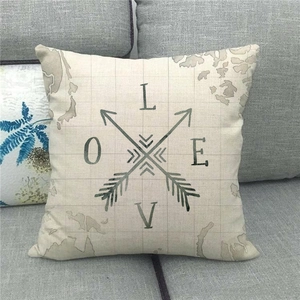 Linen pillowcase with vintage world map and LOVE text on a modern grey sofa
