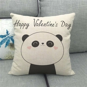 Close-up of linen pillowcase with cute panda and Happy Valentine's Day text on sofa
