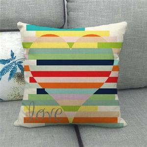 Close-up of linen pillow cover with a colorful striped heart and Love text on a gray sofa