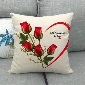 Linen Valentine's Day cushion cover with red roses and heart on a cozy grey sofa