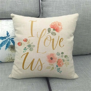 Nahaufnahme eines Leinen-Kissenbezugs mit goldenem I Love Us Text und Blumenmuster