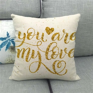 Close-up of linen pillowcase with golden you are my love script and heart on grey sofa
