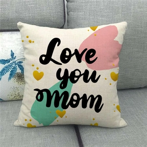 Close-up of Love You Mom linen pillow cover on a grey sofa with textured fabric detail